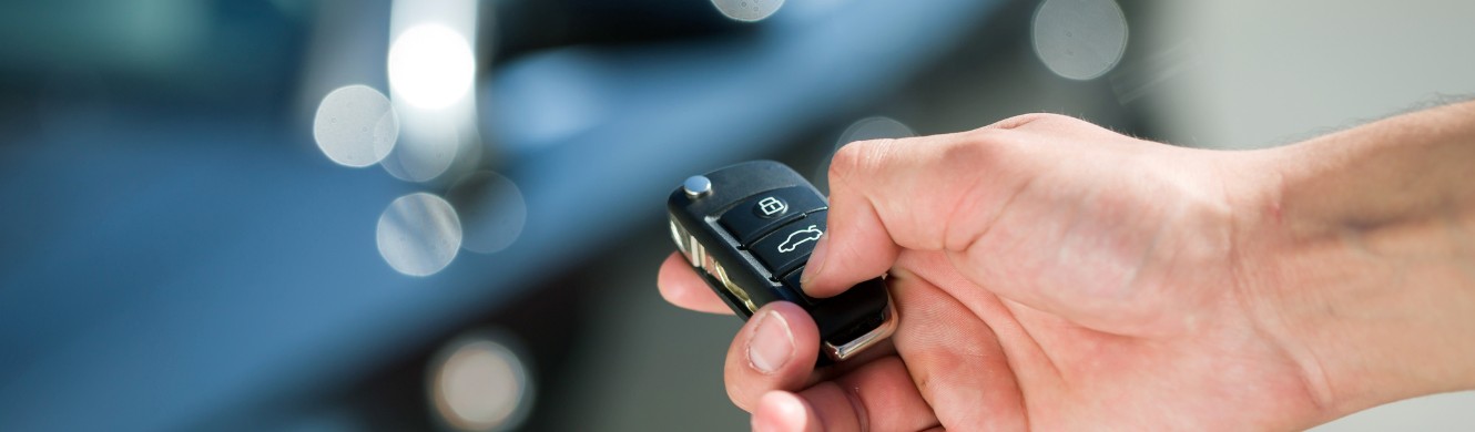 hand with car keys stand by car